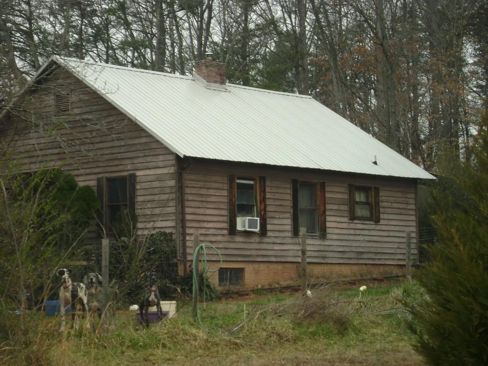 White metal roof on an old wood sided farmhouse, from a Metal Roof Installation job in Murdock